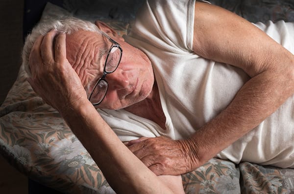 Old man lying in bed